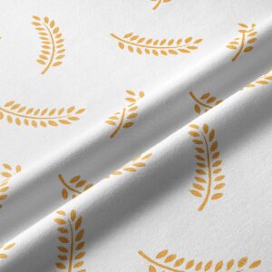 Zbliżenie na fakturę tkaniny i detal złotego nadruku gałązek