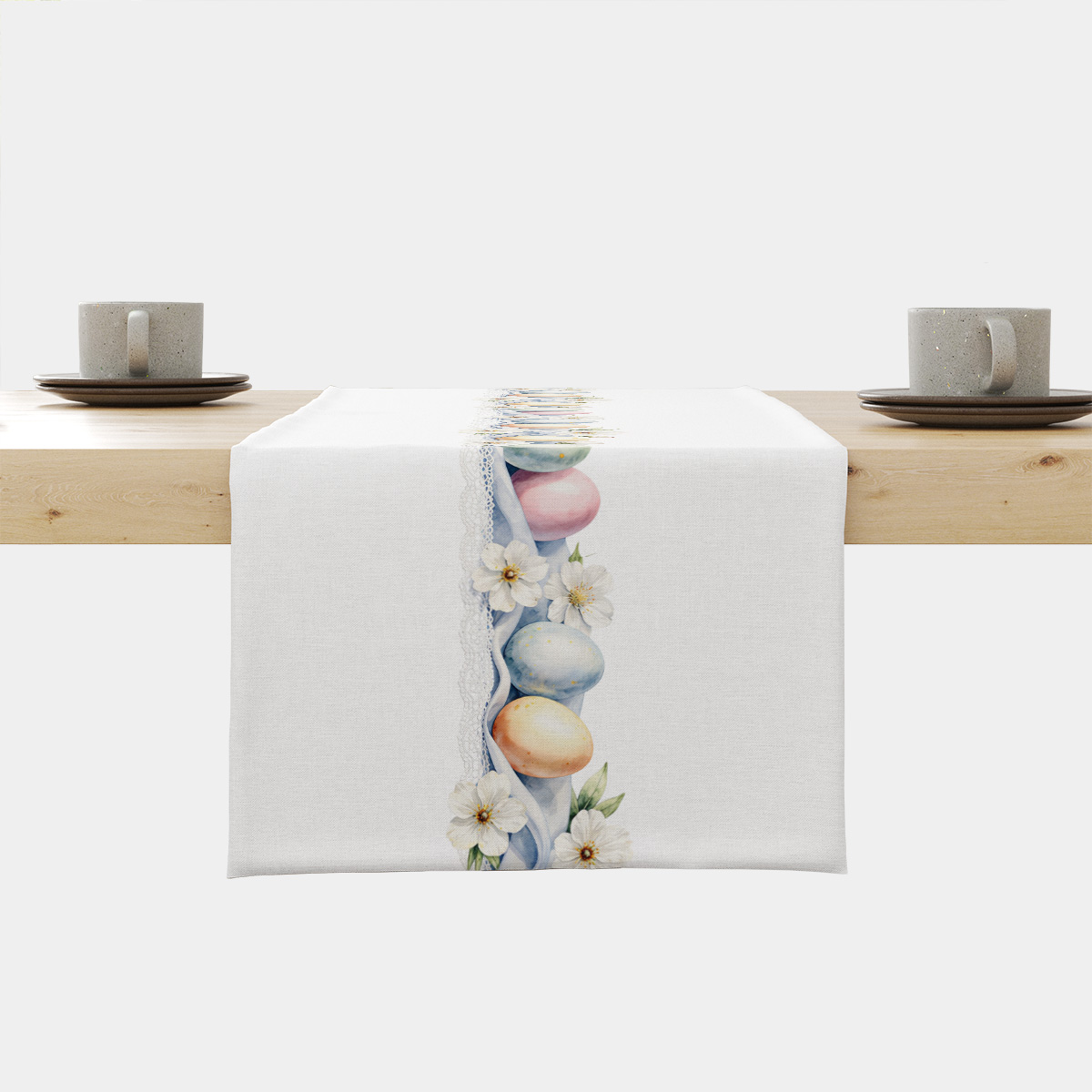 biały bieżnik z pasem pastelowych pisanek i delikatnych białych kwiatów ułożony na drewnianym stole