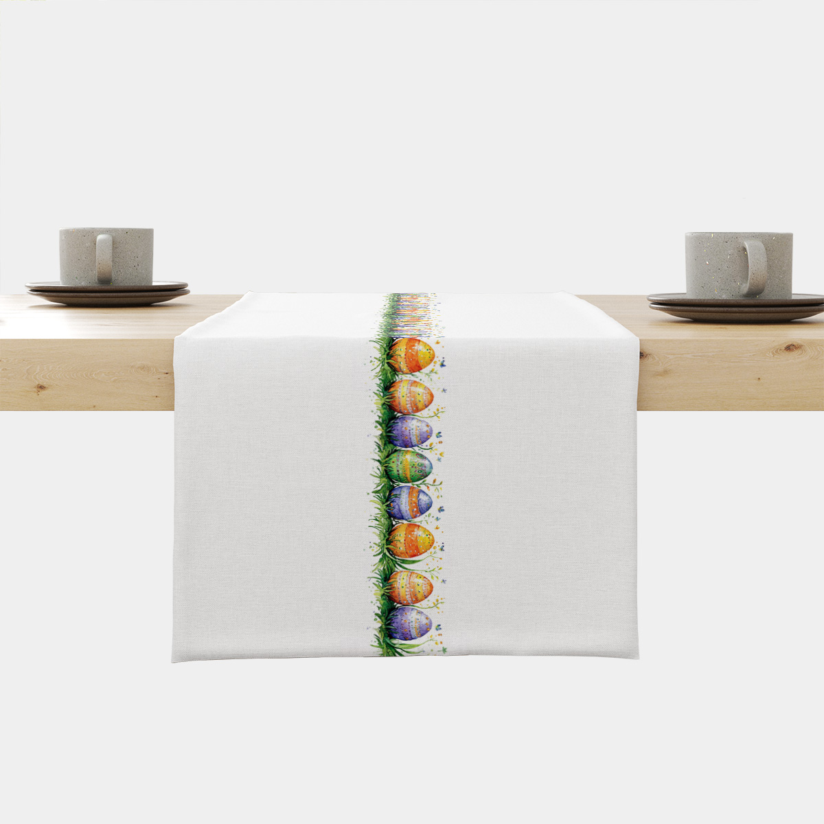 Bieżnik na stole z centralnym pasem akwarelowych pisanek w trawie