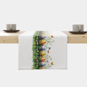 biały bieżnik z pasem kolorowych pisanek i motylami rozłożony na drewnianym stole