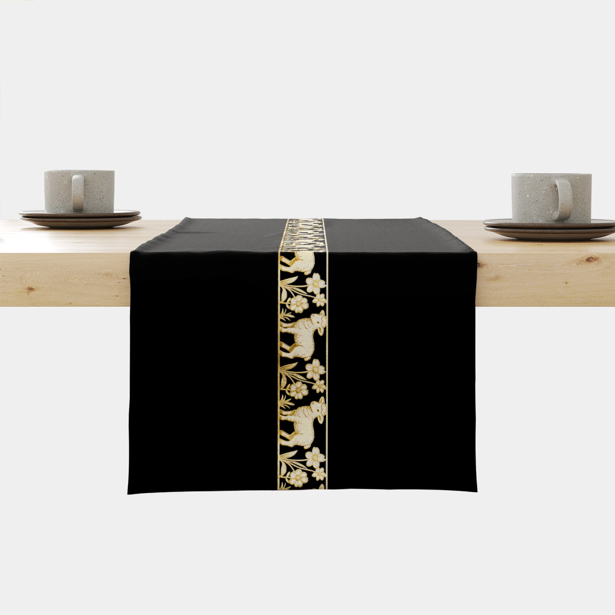 Czarny bieżnik z pionowym złotym pasem z barankami rozłożony na drewnianym stole