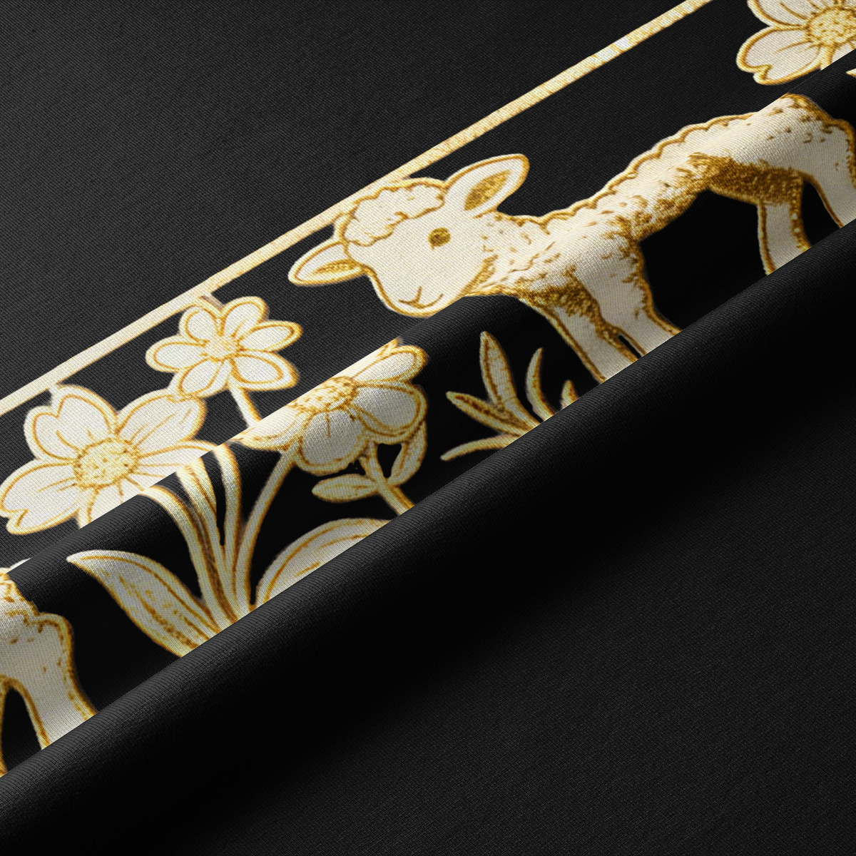 Zbliżenie na tkaninę: złoty nadruk baranka i drobnych kwiatów na czarnym tle