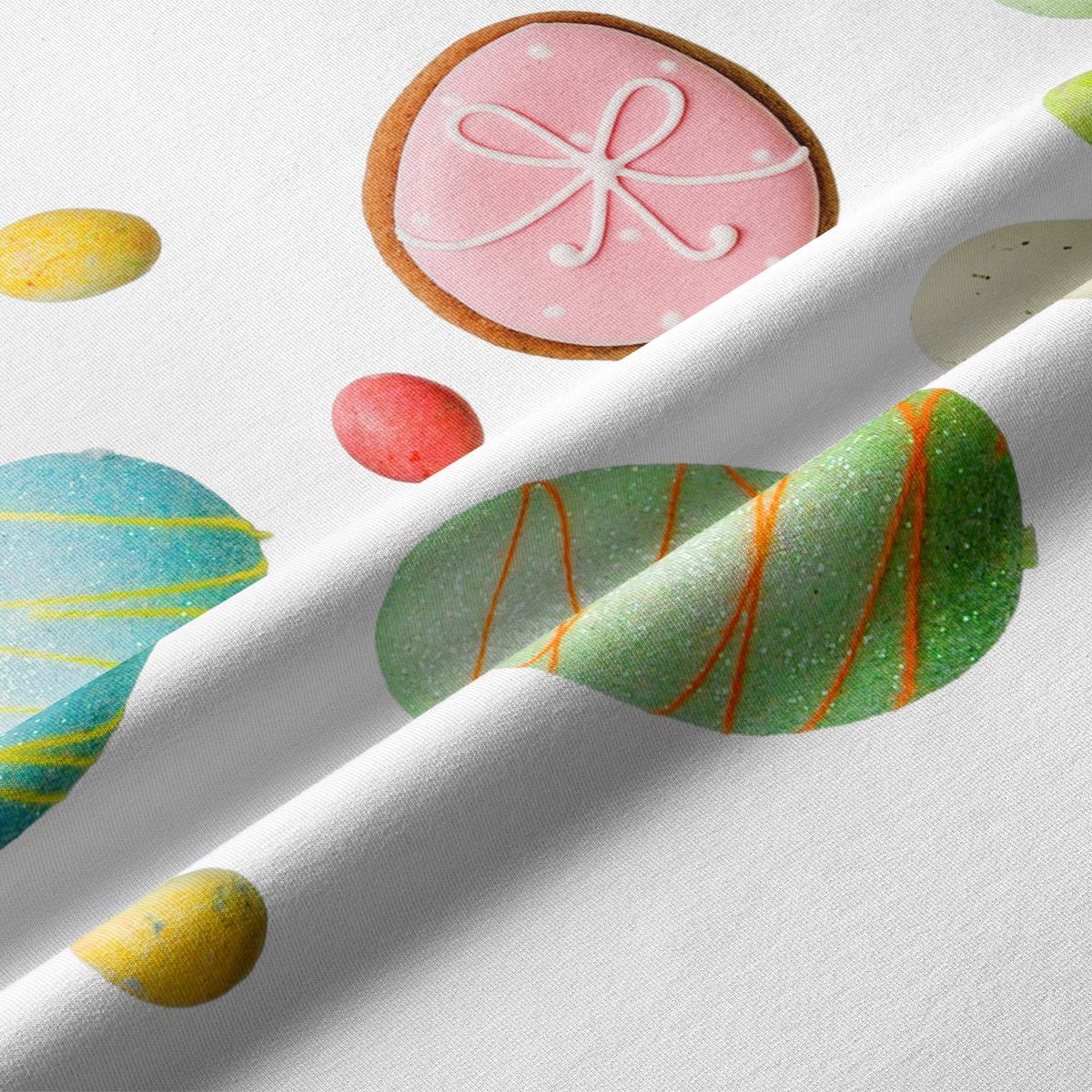 Zbliżenie na tkaninę z nadrukiem pastelowych pisanek i ciasteczek, detal faktury i kolorów