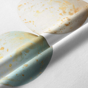 zbliżenie na tkaninę z pastelowym jajkiem i złotymi plamkami pokazujące fakturę materiału