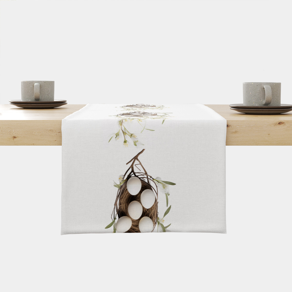 biały bieżnik z nadrukiem ptasiego gniazdka z jajkami i delikatnymi kwiatami na stole
