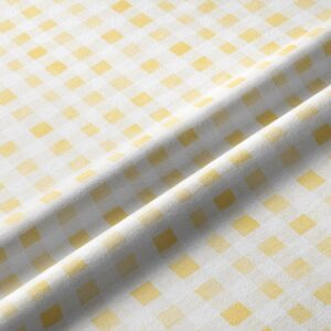 Zbliżenie tkaniny pokazujące delikatną fakturę i żółte kwadraty kratki