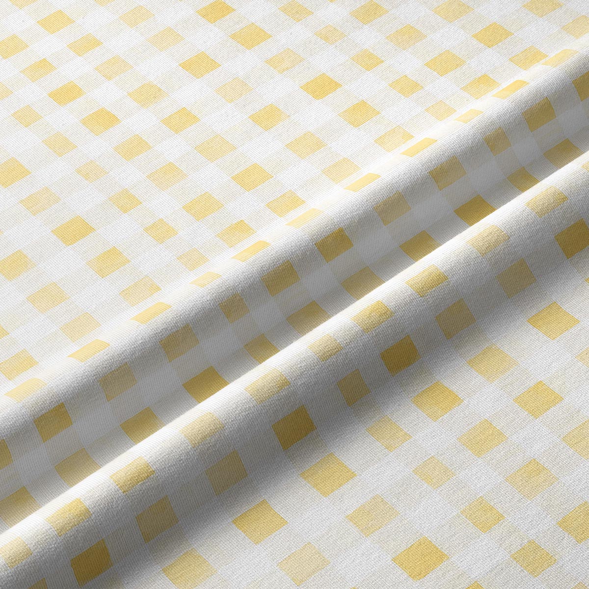 Zbliżenie tkaniny pokazujące delikatną fakturę i żółte kwadraty kratki