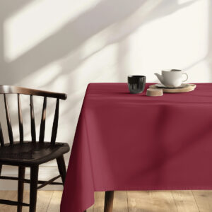 zbliżenie rogu stołu z bordowym obrusem i filiżanką na wierzchu