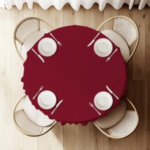 Widok z góry na nakryty stół z bordowym obrusem i zastawą dla czterech osób