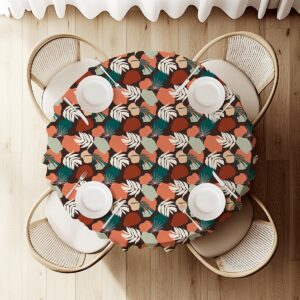 widok z góry na okrągły obrus z liściastym wzorem i nakryciami