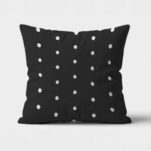 Główne ujęcie poduszki dekoracyjnej na czarnym tle z nieregularnymi białymi groszkami