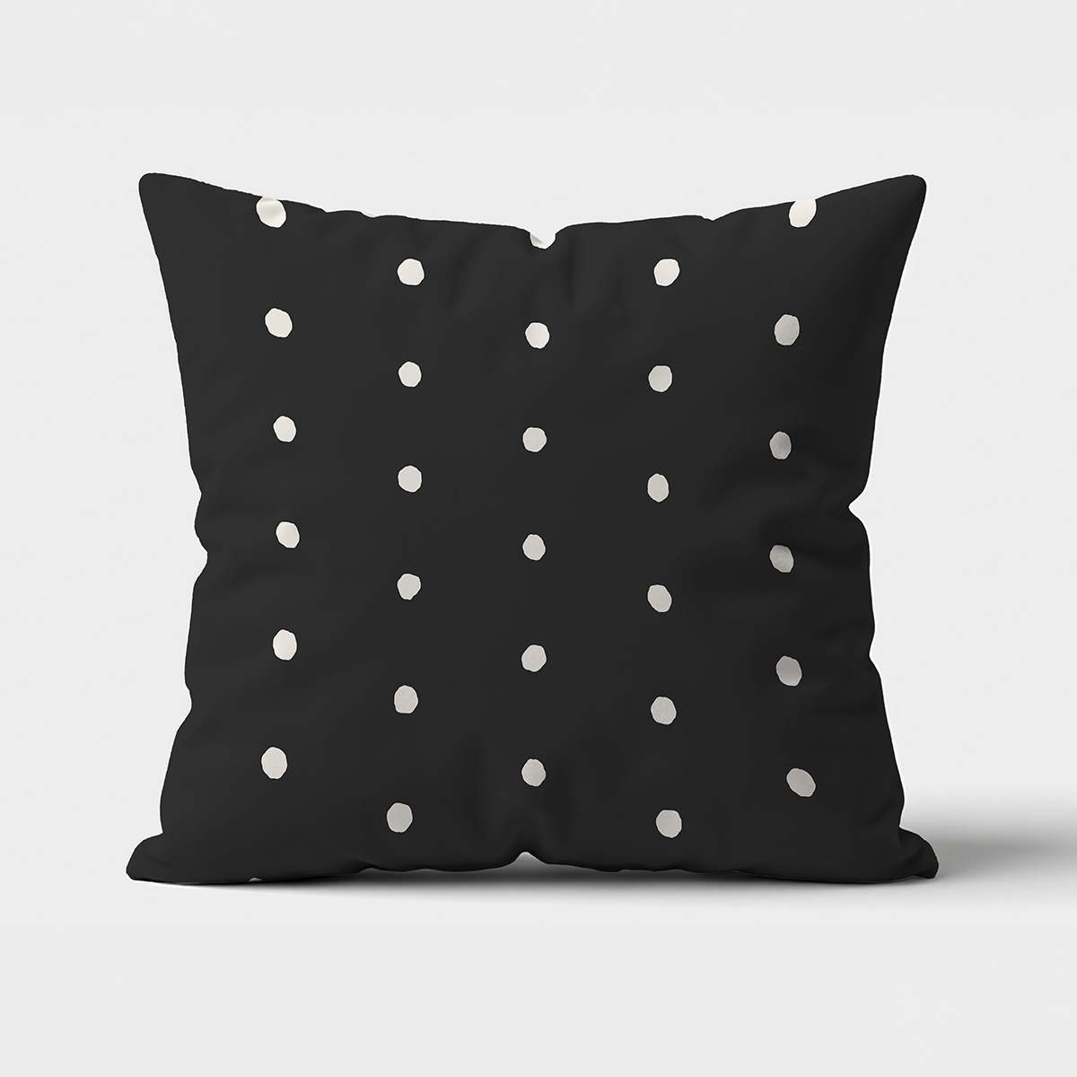 Główne ujęcie poduszki dekoracyjnej na czarnym tle z nieregularnymi białymi groszkami
