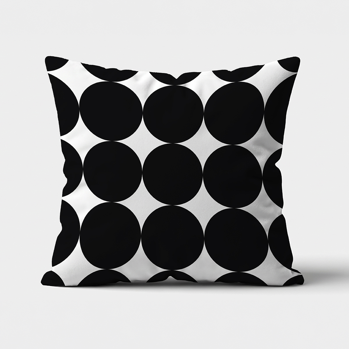 Poduszka dekoracyjna z dużymi czarnymi kółkami na białym tle — widok z przodu