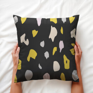 Górne ujęcie poduszki trzymanej w dłoniach, widoczne nieregularne plamy i struktura tkaniny