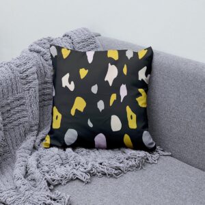 Poduszka ozdobna na szarej kanapie obok pledu, pokazana jako stylowy akcent wnętrza