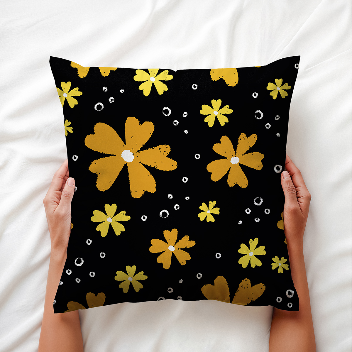 ręce trzymające poduszkę z motywem żółtych kwiatów, zbliżenie na nadruk