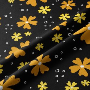 Zbliżenie na fakturę tkaniny i detal musztardowych kwiatów z białymi kropkami