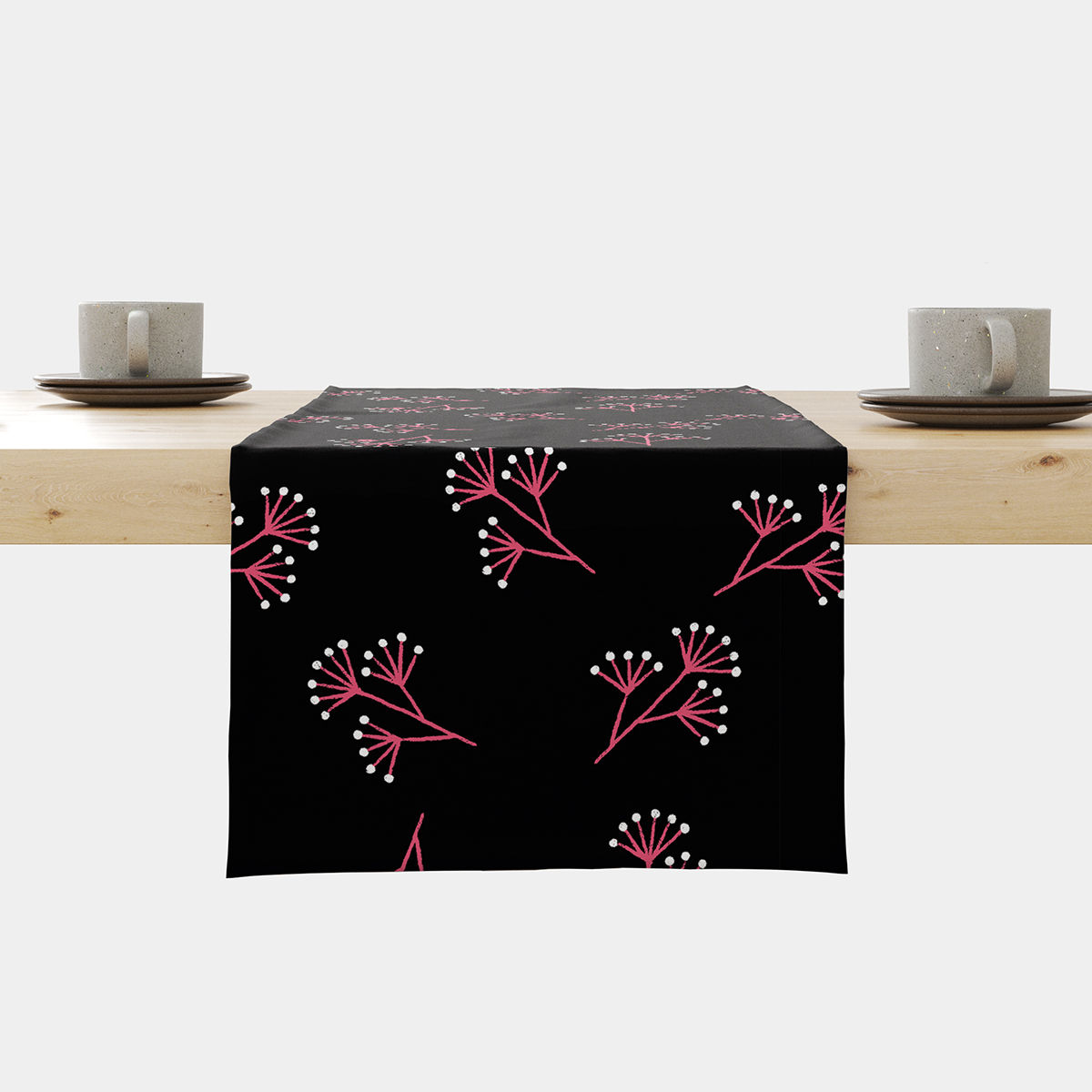 Bieżnik rozłożony na stole z czarnym tłem i regularnym wzorem różowych gałązek oraz białych kropek