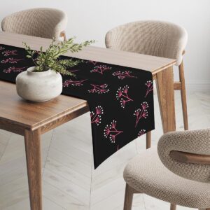 Bieżnik rozciągnięty na drewnianym stole z dekoracją w postaci doniczki, prezentujący powtarzalny układ motywu