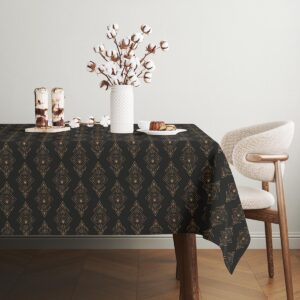 Minimalistyczne wnętrze z obrusm w geometryczne złote motywy i dekoracjami stołu