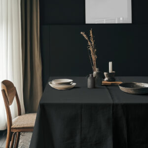 aranżacja stołu z czarnym obrusem i ceramicznymi naczyniami w stonowanej stylistyce