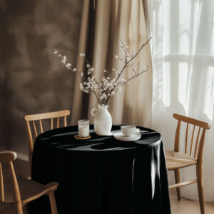aranżacja stołu z czarnym obrusem, wazonem z gałązkami i filiżanką w przytulnym wnętrzu