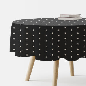 Czarny obrus okrągły z drobnymi białymi groszkami, ujęcie boczne z książkami na stole
