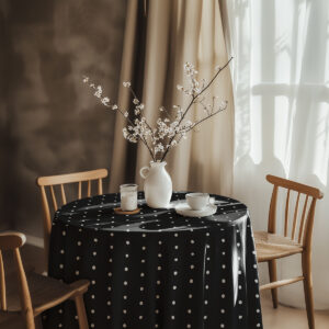 Aranżacja stołu z wazą i filiżanką na czarnym obrusie w groszki