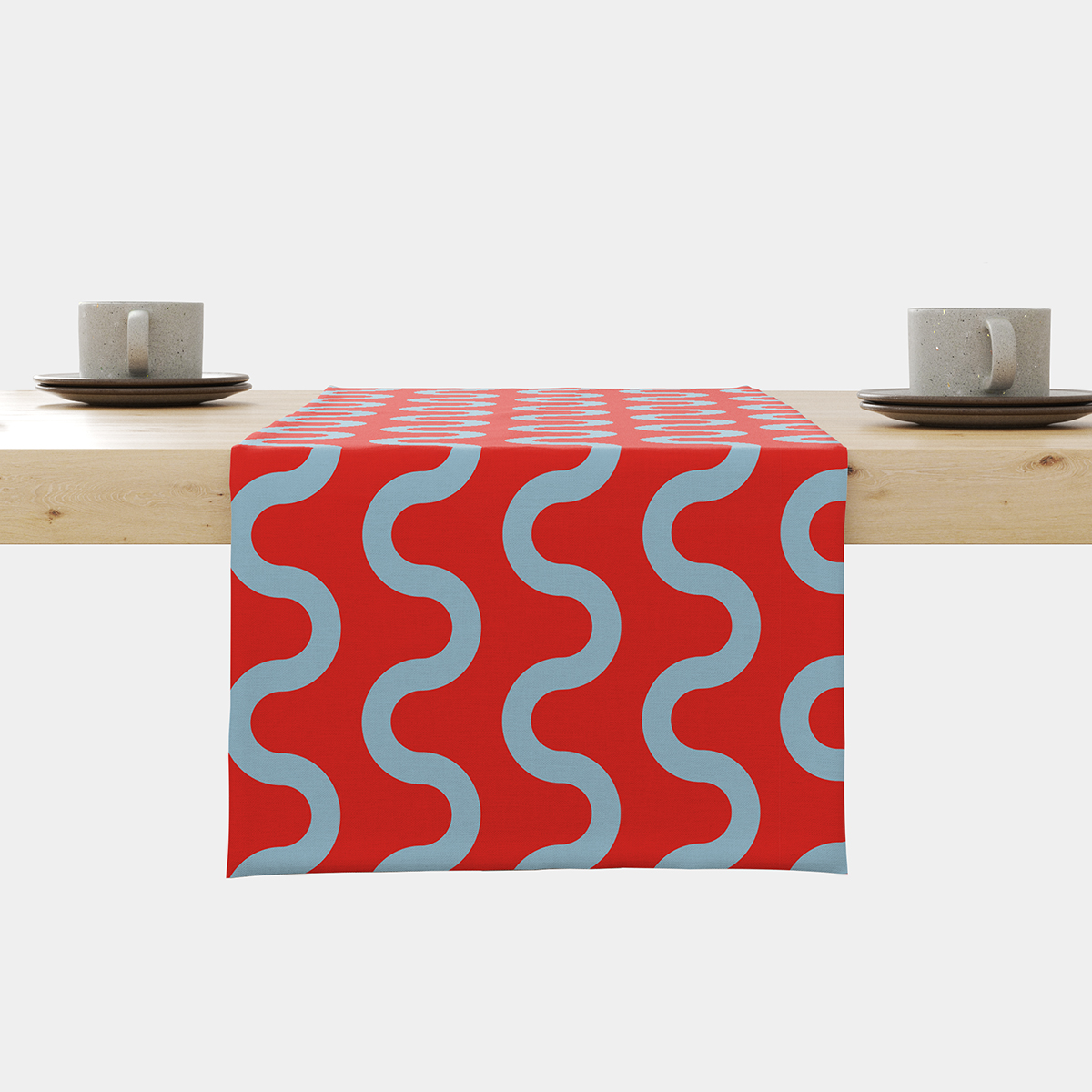 Bieżnik rozłożony na drewnianym stole, czerwone tło z regularnymi błękitnymi falami, ujęcie frontalne