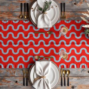 Aranżacja stołu z bieżnikiem, zastawa i złote sztućce na czerwonym tle z falistym wzorem