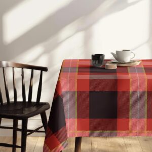 Zbliżenie rogu obrusu pokazujące kontrastowe czarne pola i czerwone pasy w kratę