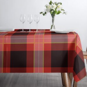 Frontalne ujęcie stołu udekorowanego obrusie z kratą, z kieliszkami i talerzami