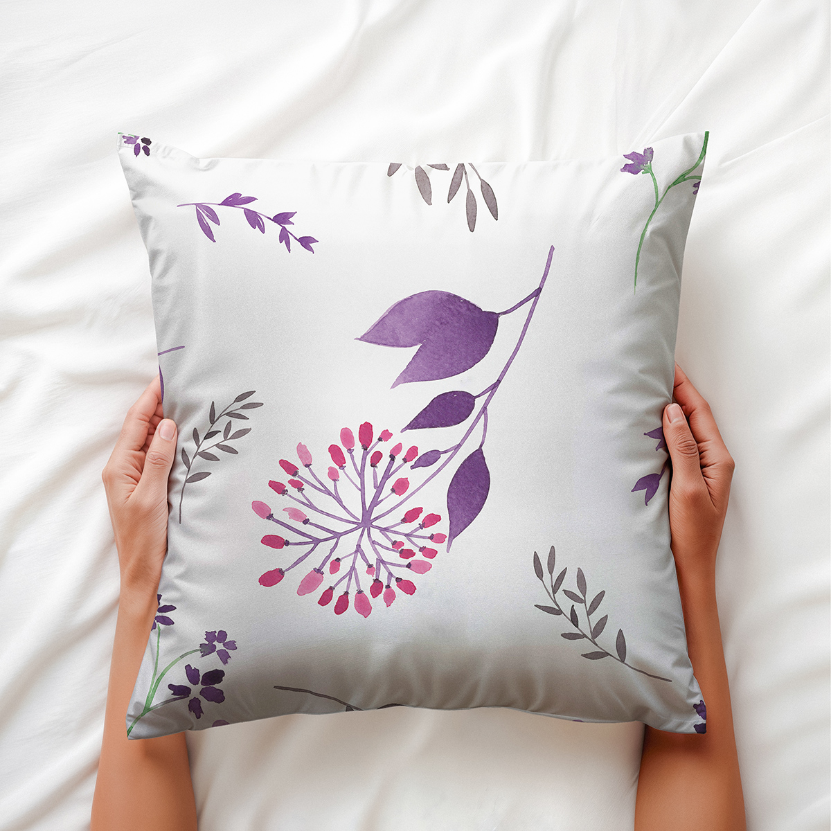 zdjęcie trzymanej poduszki ukazujące detal fioletowych liści i różowych akcentów w stylu akwareli