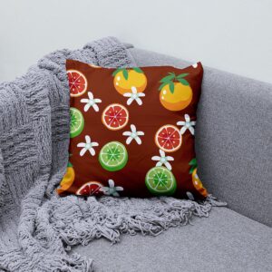Poduszka ozdobna z motywem cytrusów ułożona na szarej sofie, aranżacyjne zdjęcie