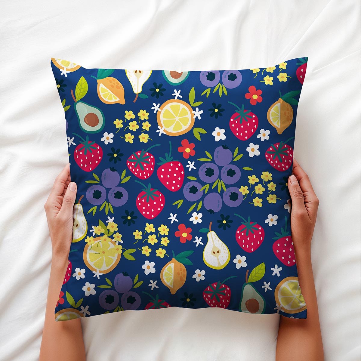 Osoba trzymająca poduszkę w dłoniach, widoczny owocowo-kwiatowy motyw i faktura