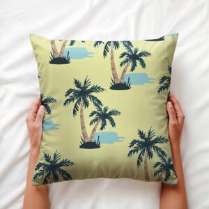 Ręce trzymające poduszkę z tropikalnym wzorem palm