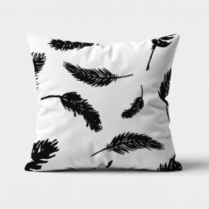 Poduszka dekoracyjna z czarnymi graficznymi piórami na białym tle, widok z przodu