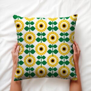 Widok z góry na poduszkę trzymaną dłońmi, pokazujący żółto-zielony motyw