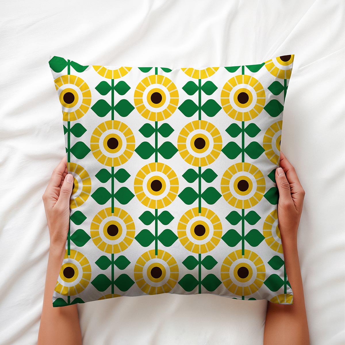 Widok z góry na poduszkę trzymaną dłońmi, pokazujący żółto-zielony motyw