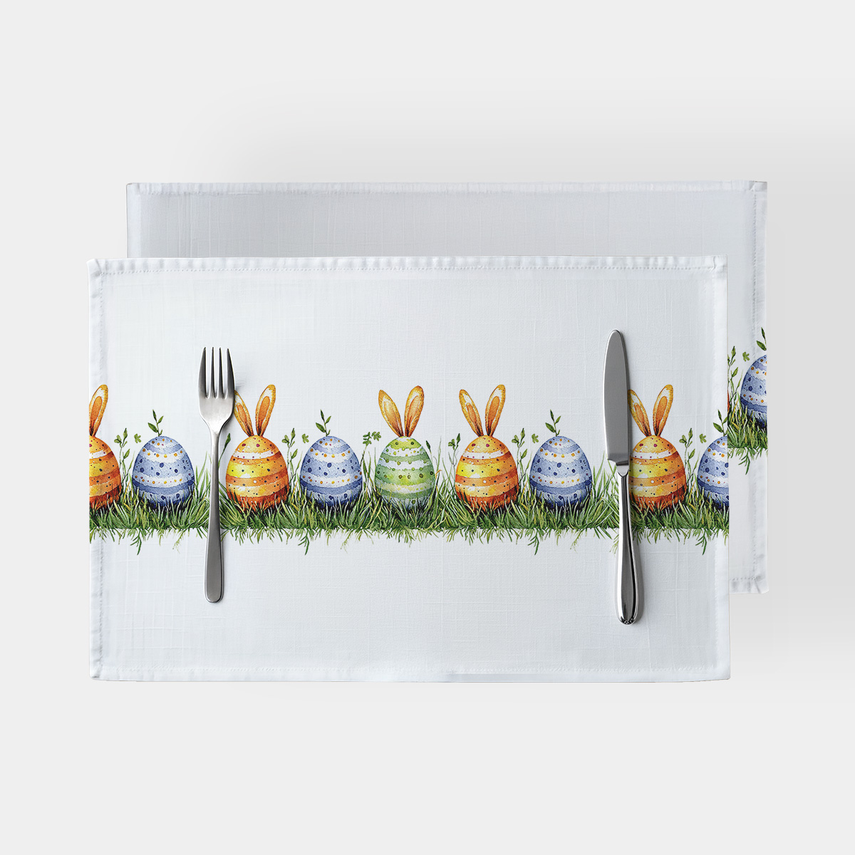 podkładka z rzędem kolorowych pisanek z króliczymi uszkami na tle białej tkaniny