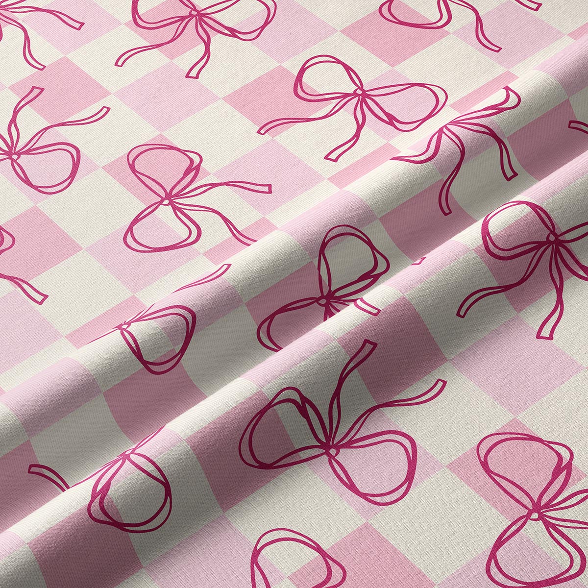 Zbliżenie na tkaninę pokazujące delikatną kratkę i rysunkowe kokardki