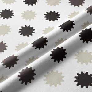 Zbliżenie tkaniny pokazujące nadruk beżowych i brązowych rozbłysków i strukturę materiału