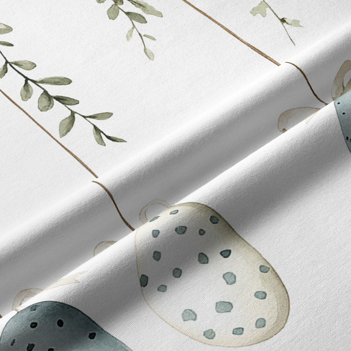 Zbliżenie tkaniny z akwarelowym jajkiem w kropki i widoczną fakturą materiału