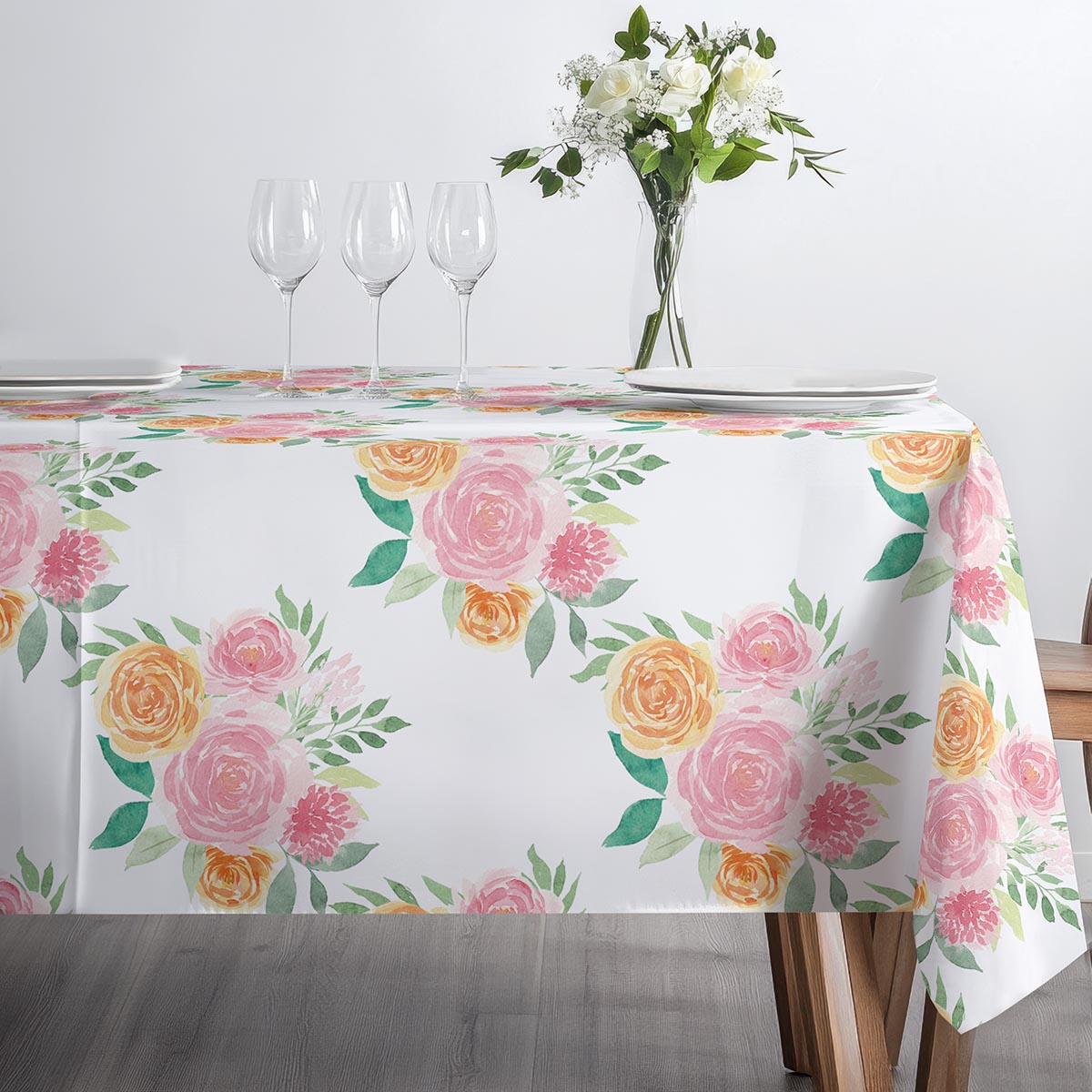 Frontowy widok stołu z zastawą i rozłożonym obrusem w pastelowe bukiety
