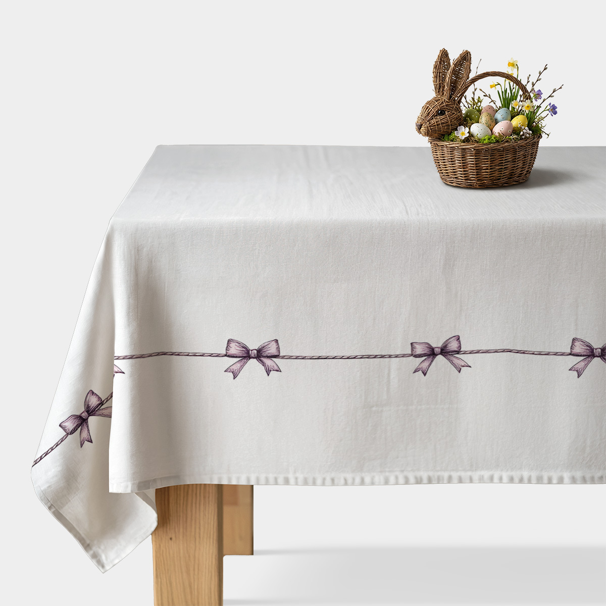 biały obrus z delikatną linią fioletowych kokardek na brzegu stołu