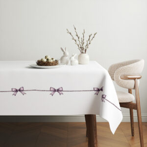 aranżacja stołu ze świątecznymi dekoracjami i obrusem z kokardkami