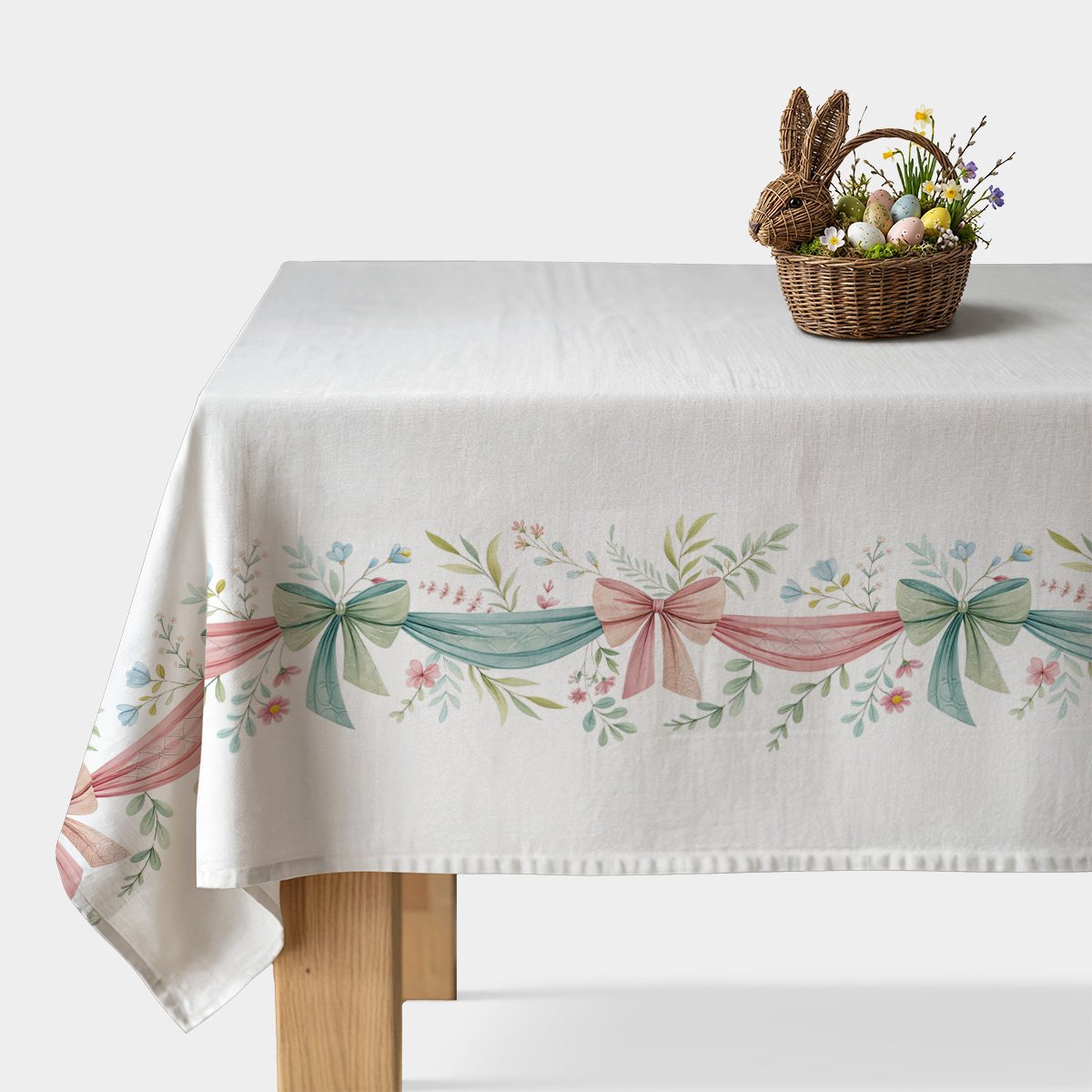 Główny widok obrus z pastelowymi wstążkami i gałązkami na białym stole z koszykiem pisanek
