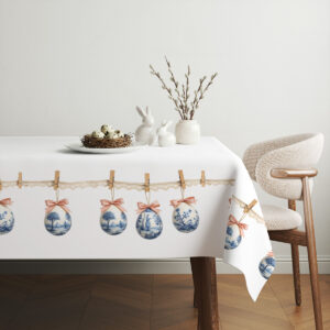 aranżacja stołu z obrusem, gniazdo z jajkami i gałązki kotków tworzące świąteczną dekorację