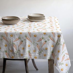 Widok stołu z zastawą na obrusie w wiosennej, świątecznej aranżacji