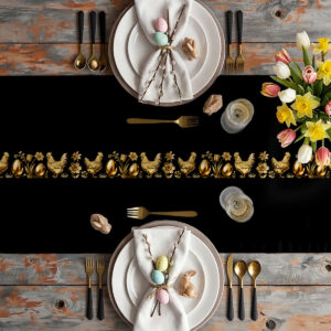 Aranżacja stołu z czarnym bieżnikiem ozdobionym złotym wzorem kurek i pisanek obok talerzy i bukietu tulipanów